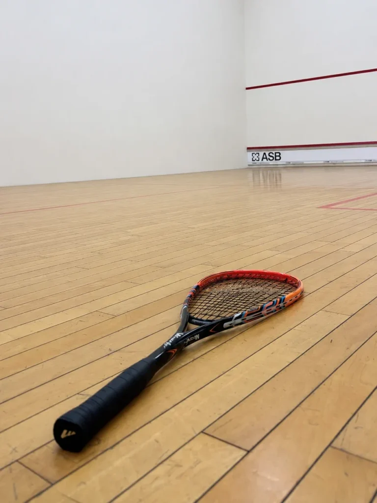 Indoor squash court with racket on wooden floor in Muscat Oman