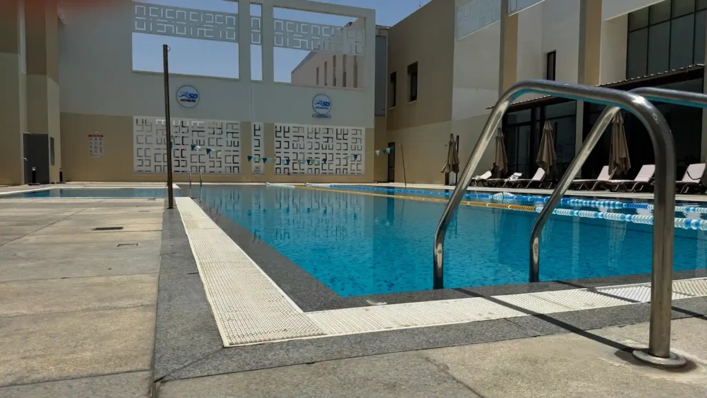 Outdoor swimming pool in Muscat, Oman with swim lanes, pool ladder, and fitness club facilities