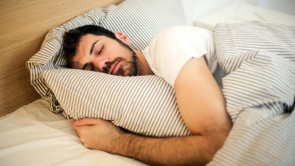 Man sleeping during a rest day to support fitness recovery and muscle repair in Oman